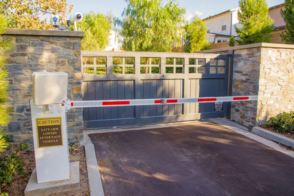Community entry gate with surveillance and barrier arm.