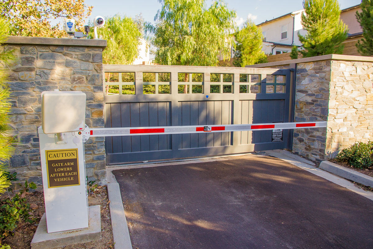 Community entry gate with surveillance and barrier arm.