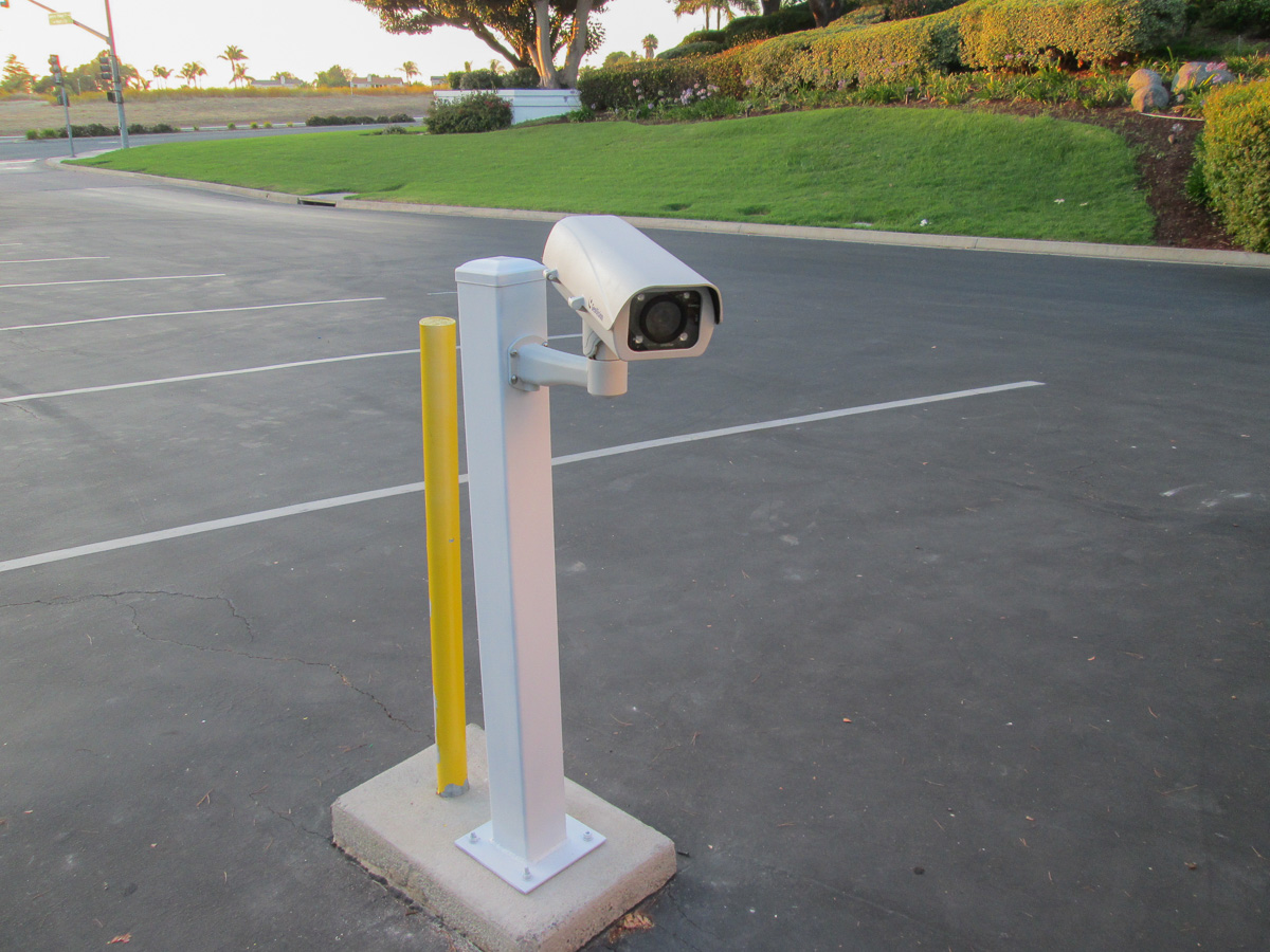Mounted surveillance camera in a parking lot.